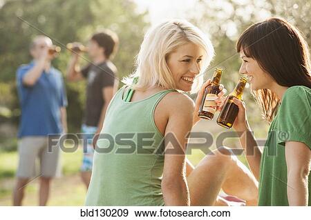 Women drinking beer outdoors View Large Photo Image Stock Photo - Women drinking beer outdoors. Fotosearch