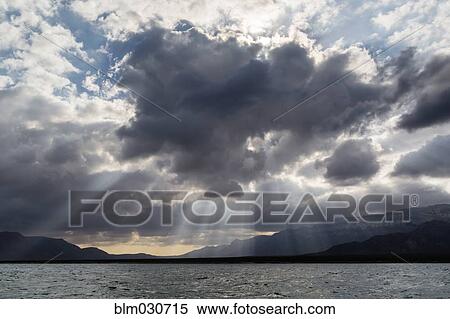 Beams of light streaming through clouds View Large Photo Image Stock Photography - Beams of light streaming through clouds. Fotosearch