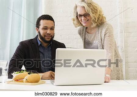 Business people having lunch together in office View Large Photo Image Stock Photo - Business people having lunch together in office. Fotosearch