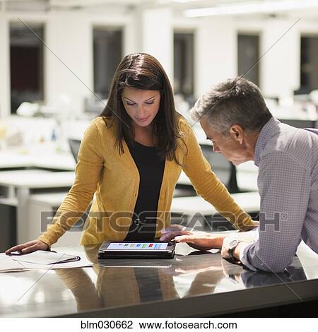 Business people using digital tablet in office View Large Photo Image Stock Image - Business people using digital tablet in office. Fotosearch