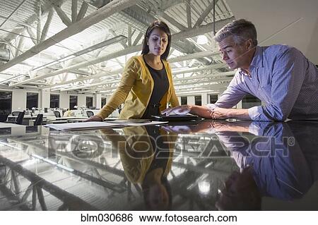 Stock Photograph - Business people working late in office. Fotosearch