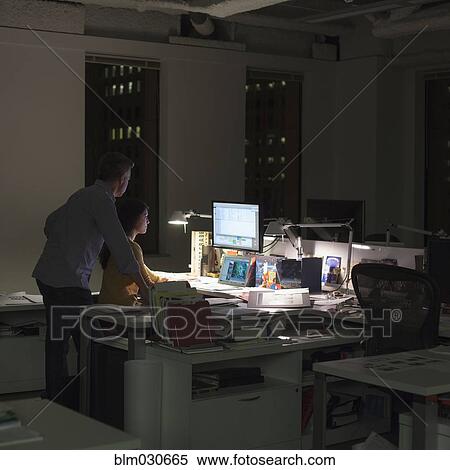 Stock Photography - Business people working late in office. Fotosearch