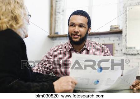 Stock Image - Businesswoman talking to young businessman. Fotosearch