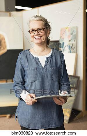 Stock Image - Caucasian artist smiling in studio. Fotosearch