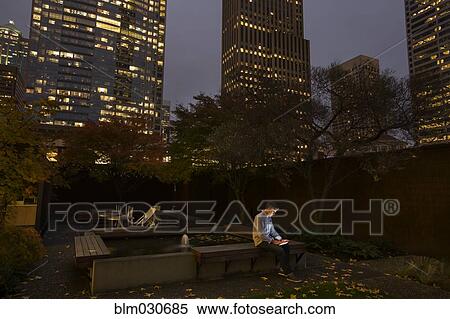 Stock Photography - Caucasian businessman using digital tablet in urban courtyard. Fotosearch