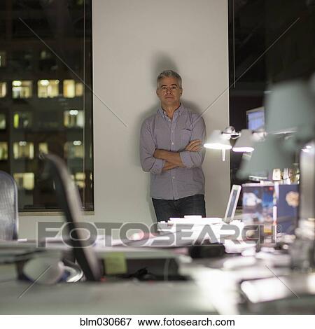 Stock Photo - Caucasian businessman working late in office. Fotosearch