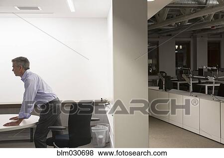 Stock Photo - Caucasian businessman working late in office. Fotosearch