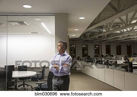 Stock Photograph - Caucasian businessman working late in office. Fotosearch