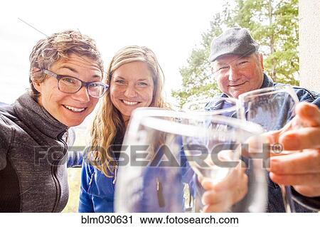 Stock Image - Caucasian family drinking wine together. Fotosearch