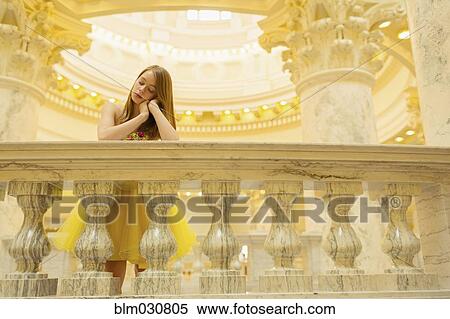 Stock Photography - Caucasian teenage girls wearing gown by ornate banister. Fotosearch