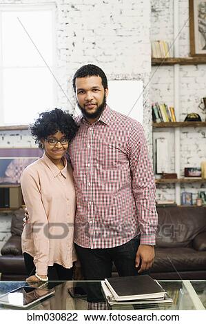Stock Image - Couple smiling in home office. Fotosearch