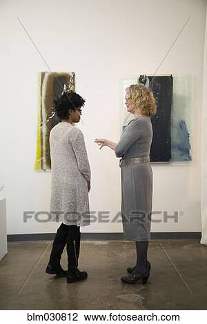 Gallery owner talking to patron View Large Photo Image Stock Image - Gallery owner talking to patron. Fotosearch