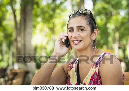 Stock Photo - Hispanic woman talking on cell phone. Fotosearch