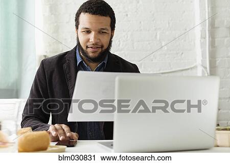 Mixed race businessman working at desk View Large Photo Image Stock Image - Mixed race businessman working at desk. Fotosearch