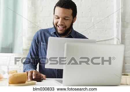 Mixed race businessman working at desk View Large Photo Image Stock Image - Mixed race businessman working at desk. Fotosearch