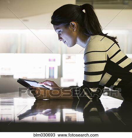 Stock Image - Mixed race businesswoman using digital tablet in office. Fotosearch