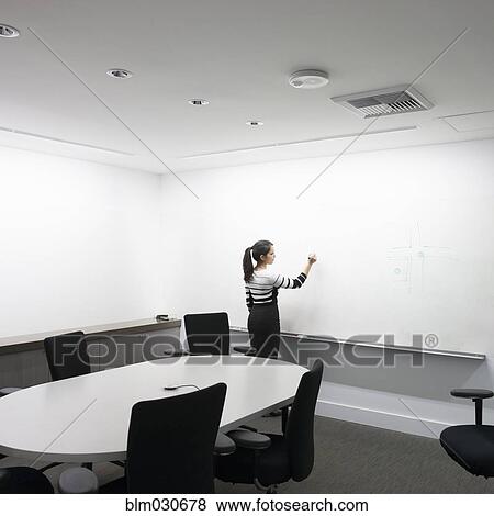 Stock Photo - Mixed race businesswoman writing on whiteboard. Fotosearch