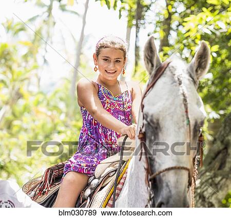 Mixed race girl riding horse in jungle View Large Photo Image Stock Photo - Mixed race girl riding horse in jungle. Fotosearch