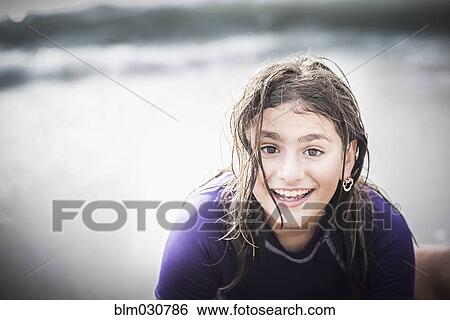 Stock Photograph - Mixed race girl with wet hair at beach. Fotosearch
