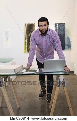 Picture - Mixed race man working in art gallery. Fotosearch