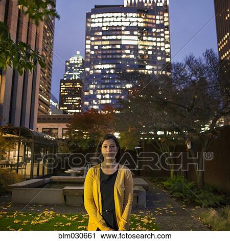 Stock Image - Mixed race woman smiling in urban courtyard. Fotosearch