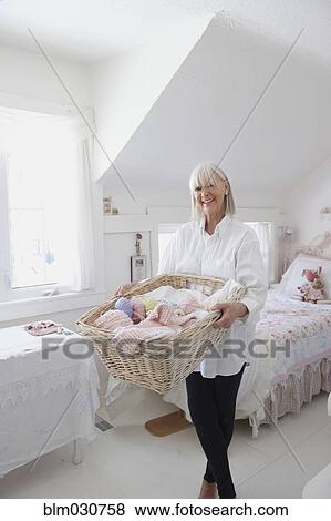 Stock Photo - Senior Caucasian woman holding basket of knitting. Fotosearch