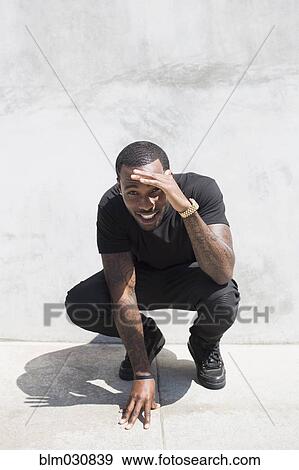 Stock Photo - African American man smiling on city street. Fotosearch