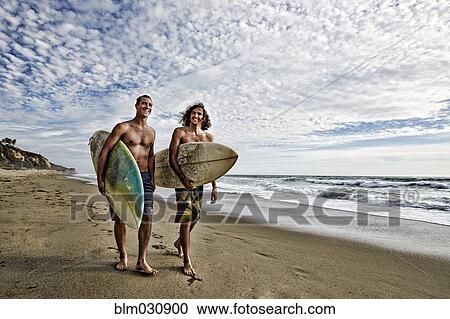 Caucasian men carrying surfboards on beach View Large Photo Image Stock Image - Caucasian men carrying surfboards on beach. Fotosearch