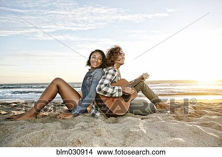 Picture - Couple relaxing together on beach. Fotosearch