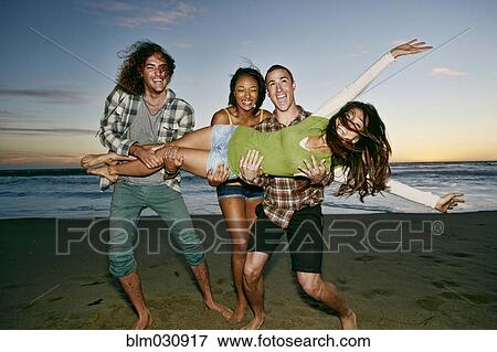 Stock Photo - Friends posing together on beach. Fotosearch