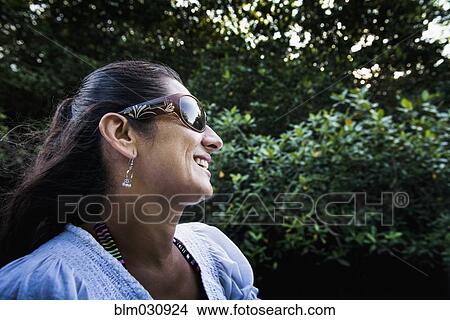 Picture - Hispanic woman smiling outdoors. Fotosearch