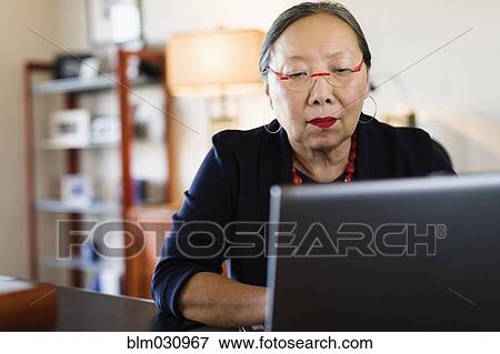 Japanese businesswoman working at desk View Large Photo Image Stock Photo - Japanese businesswoman working at desk. Fotosearch