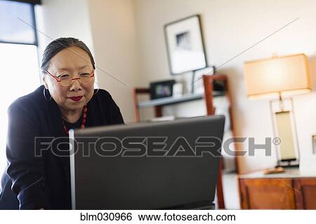 Stock Photograph - Japanese businesswoman working at desk. Fotosearch