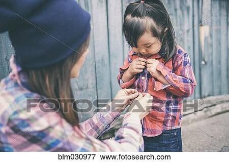 Korean mother helping daughter button her shirt View Large Photo Image Stock Photo - Korean mother helping daughter button her shirt. Fotosearch