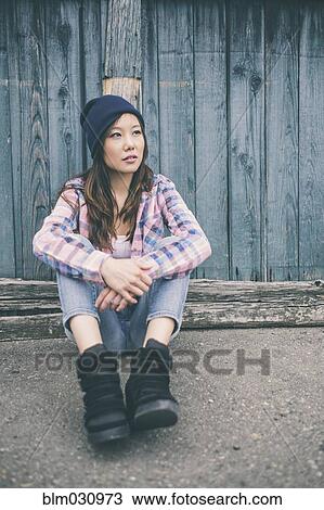 Korean woman sitting on city street View Large Photo Image Stock Image - Korean woman sitting on city street. Fotosearch