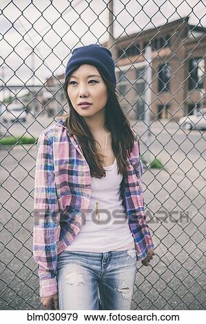 Stock Photo - Korean woman standing on city street. Fotosearch