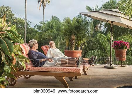 Older Caucasian couple relaxing by pool View Large Photo Image Stock Photograph - Older Caucasian couple relaxing by pool. Fotosearch