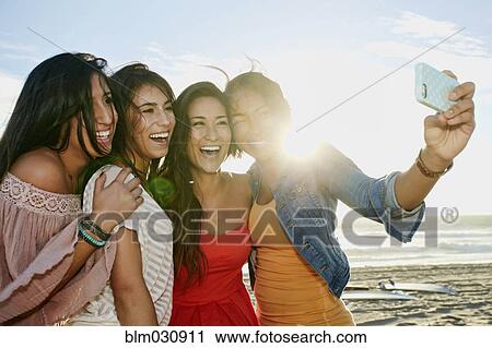 Women taking pictures together on beach View Large Photo Image Stock Image - Women taking pictures together on beach. Fotosearch