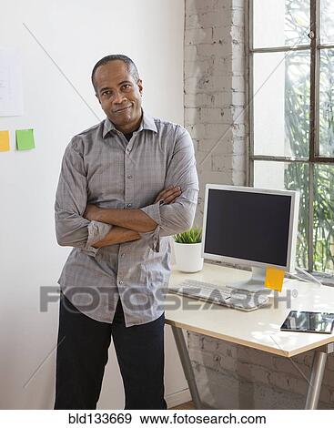 Stock Photo - African American architect smiling in office. Fotosearch