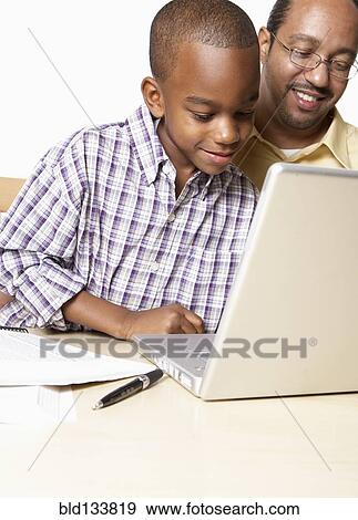 African American father and son using laptop View Large Photo Image Stock Photo - African American father and son using laptop. Fotosearch