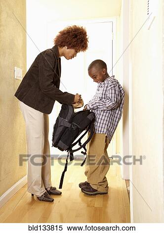 Stock Photography - African American mother getting son ready for school. Fotosearch
