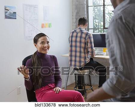 Stock Photo - Architects talking in office. Fotosearch