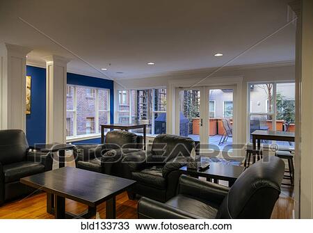 Stock Image - Armchairs and coffee tables in common area. Fotosearch