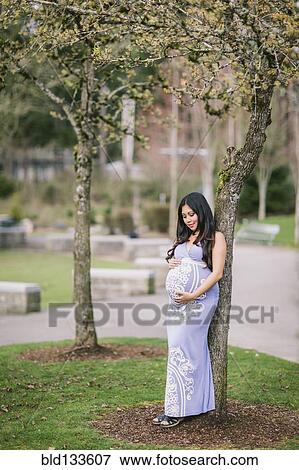 Stock Photo - Asian woman holding her pregnant belly. Fotosearch