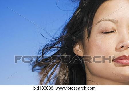 Asian woman with eyes closed outdoors View Large Photo Image Stock Image - Asian woman with eyes closed outdoors. Fotosearch