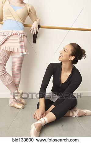 Stock Image - Ballet dancers relaxing in studio. Fotosearch