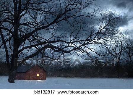 Stock Photo - Bare tree over lit barn in snowy meadow. Fotosearch