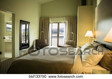 Bed and chairs in hotel room View Large Photo Image Stock Image - Bed and chairs in hotel room. Fotosearch