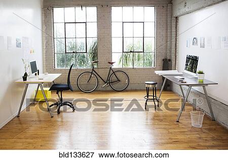 Stock Photo - Bicycle and desks in modern office. Fotosearch