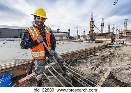Stock Photo - Black worker smiling at construction site. Fotosearch